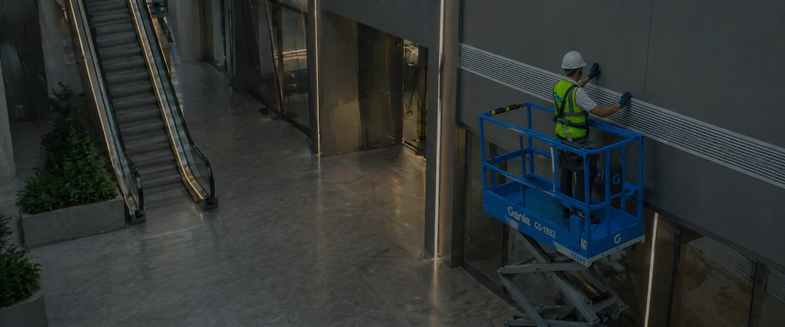 Powered access operator working on a scissor lift indoors